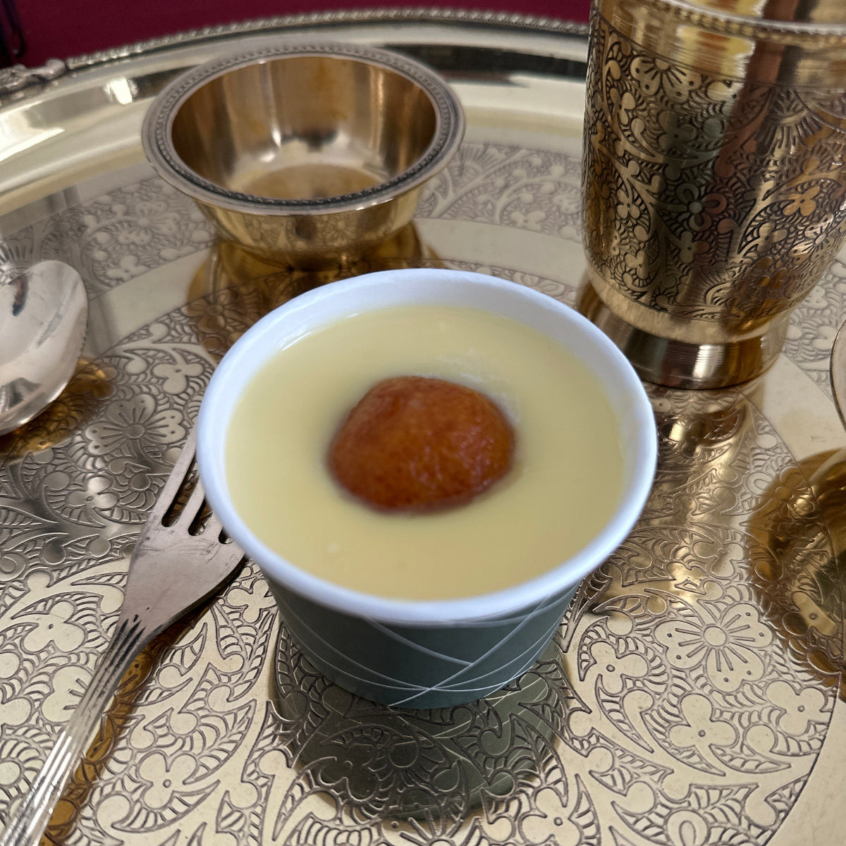 A bowl of rich, creamy dessert custard garnished with premium almonds and pistachios.