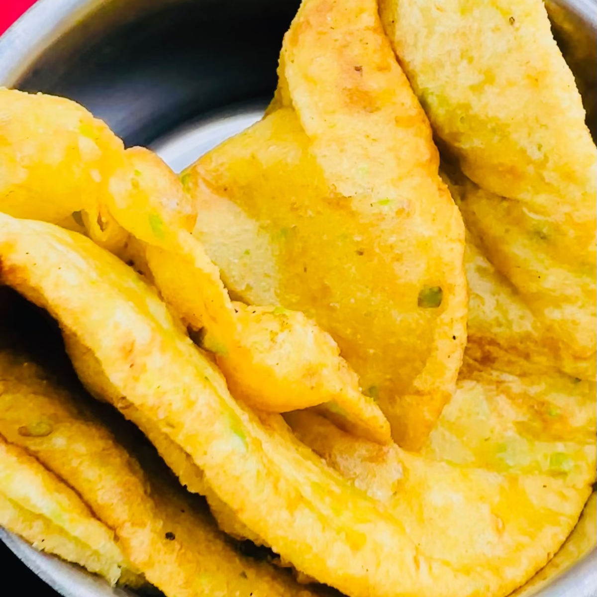 Freshly fried, golden, and puffed Indian Puri bread.